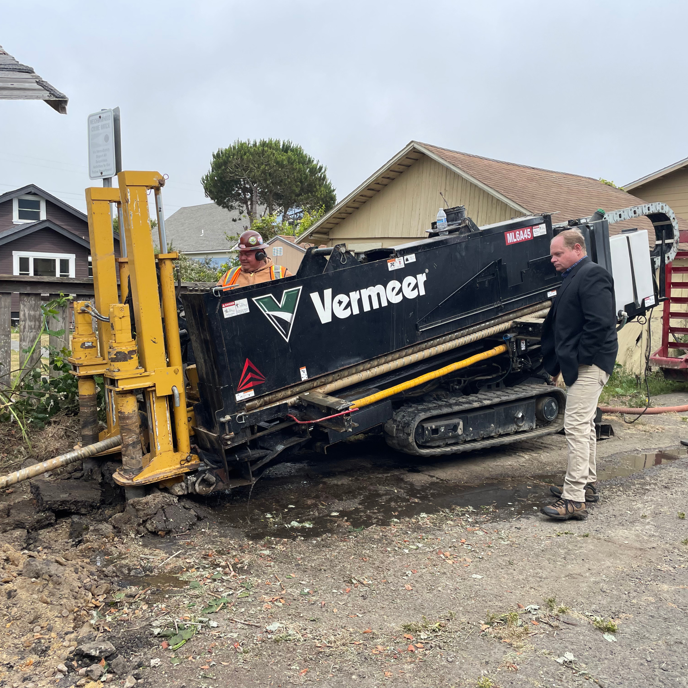 MMBI Deputy Director Mark Monroe watches as a construction worker drills a hole for conduit to be pulled through.